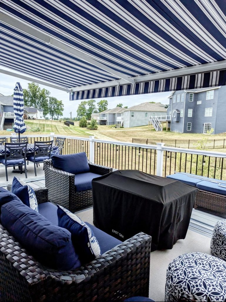 porch with blue and white striped awning and blue, white, and black furniture. Home improvements that increase home value