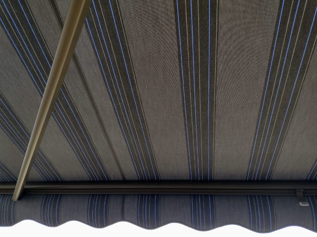 view of underneath a blue, yellow, and tan striped awning