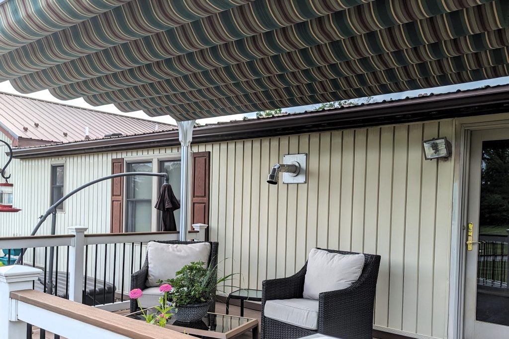 Back deck covered with a striped green, tan, and red retractable canopy.